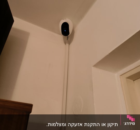 מצלמת אבטחה מותקנת בפינת תקרה עם כבל חשמל